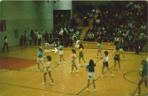 Girls dancing on a basketball court  wearing shorts and leis.